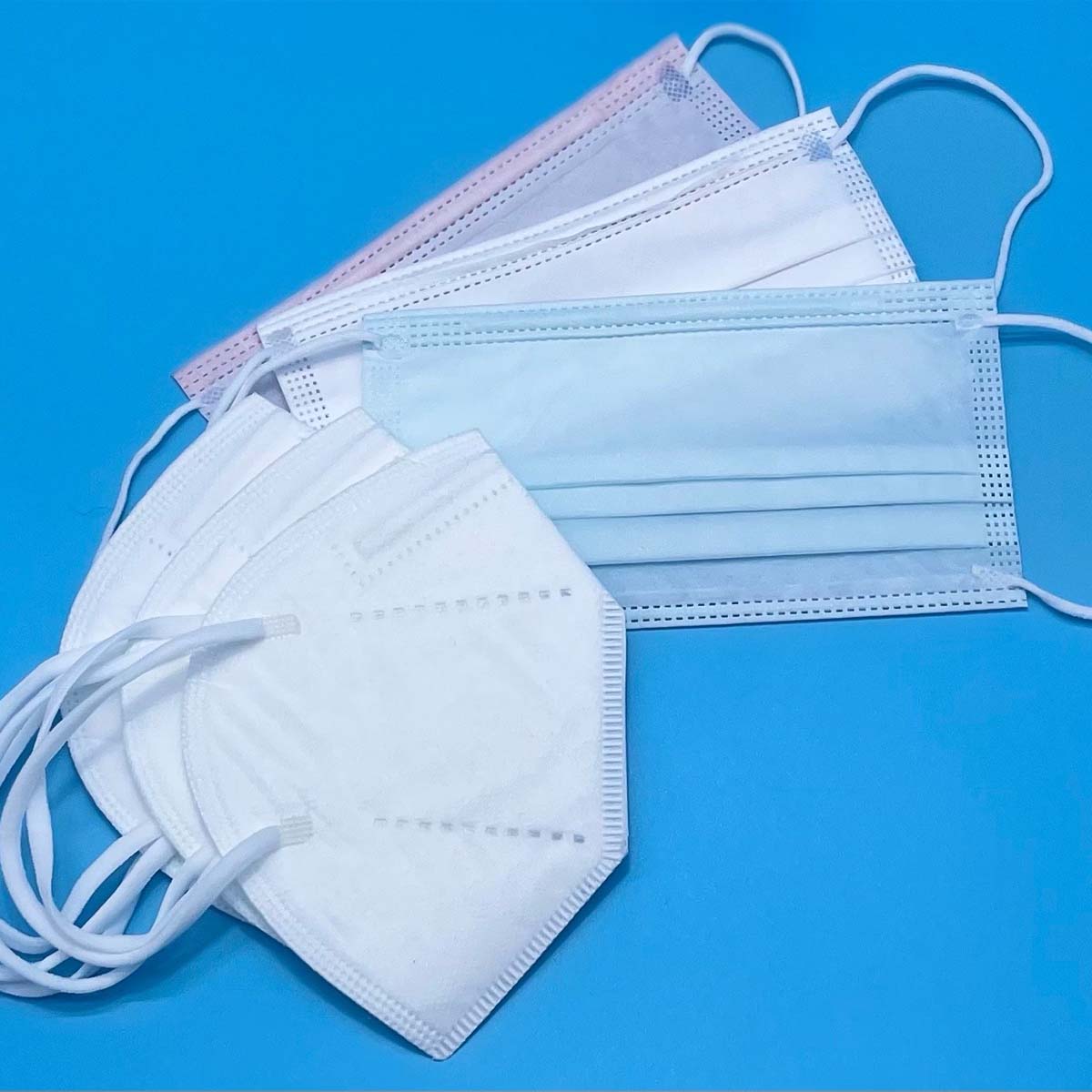 Image of a Pink, White, and Blue American Made Surgical style mask and three white American Made KN95 style mask